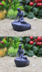 Detalle de escultura de sirena estilo bronce sobre base de mármol en micro paisaje