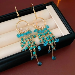 Détails de boucles d'oreilles dorées vintage avec étoiles et pompon perlé bleu en boîte