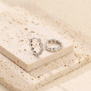 Macro shot of S925 sterling silver geometric rhombus hoop earrings on stone background