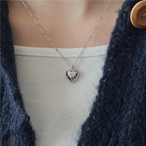 Close-up of a 925 sterling silver heart necklace with zircon inlay on a model