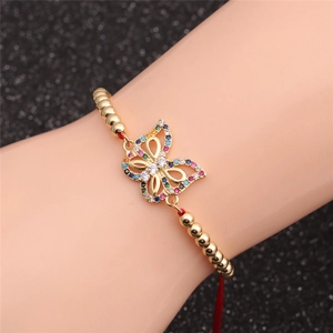 Detailed view of a gold-plated butterfly bracelet with colorful zircons on a red cord