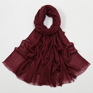 Detail of dark red slub cotton scarf showing breathable texture and fringe edges