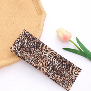 Detail showing leopard print headband with dimensions 20cm by 7.87in and elastic fabric texture