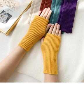 Detail of warm knitted fingerless gloves showing extended ribbed cuffs in yellow color