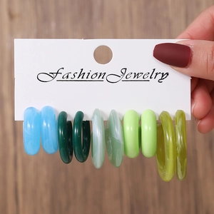 Détail de cinq paires de boucles d'oreilles créoles en résine acrylique colorée en C