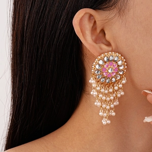 Close-up of gold earrings with pink oil drop petals and white imitation pearl tassels