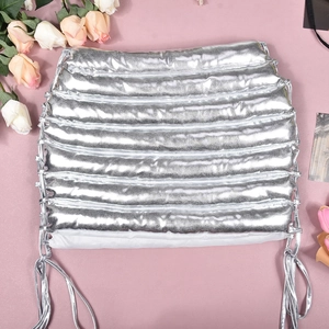 Close-up of metallic silver quilted mini skirt with side drawstring adjusters