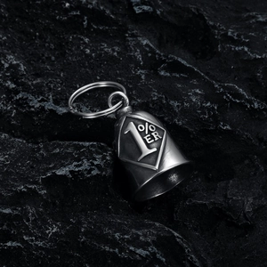 Macro detail of vintage motorcycle bell pendant with 1% ER engraving on volcanic stone