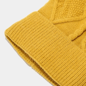Close-up detail of the vibrant yellow chunky knit pattern and ribbed texture on the beanie
