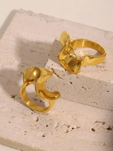 Close-up of dual 18k gold plated stainless steel rings with fluid wave-like design