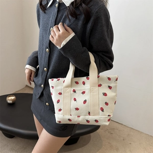 Chic cream corduroy tote bag with strawberry print featuring wide canvas handles for women