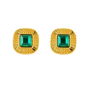 Detail of vintage gold square earrings with green stone and radiating relief textures