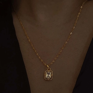 Golden stainless steel necklace featuring a square zircon pendant on a wave chain
