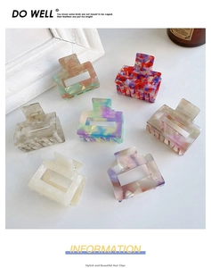 Detail of square cutout acetate hair claws with multi-colored marble texture patterns