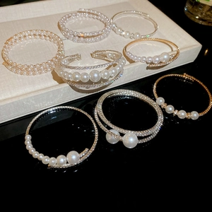 Macro shot of multi-layer pearl bracelets with rhinestones on beige and black displays
