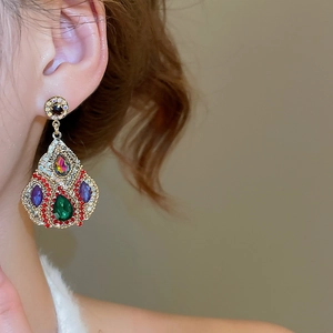Detail of vintage bohemian drop earrings with multi-colored crystals and gold finish