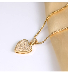 Close-up of a gold heart pendant with pavé cubic zirconia on a twisted rope chain