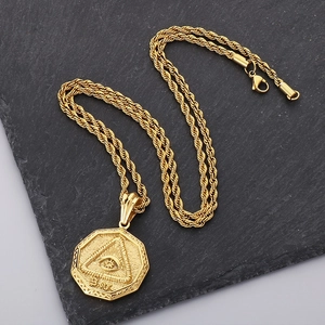 Detailed close-up of golden octagonal Eye of Providence pendant on vintage slate background