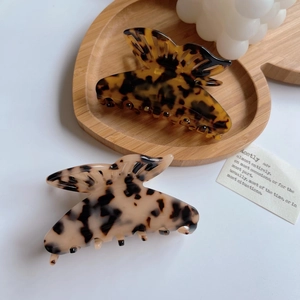 Detail view of acetate butterfly hair claws in tortoiseshell and floral patterns