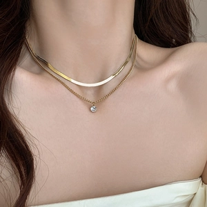 Elegant gold double-layered snake chain necklace with a sparkling zircon pendant on model