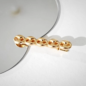 Detailed close-up of golden vintage minimalist alloy hair clip showing metallic texture