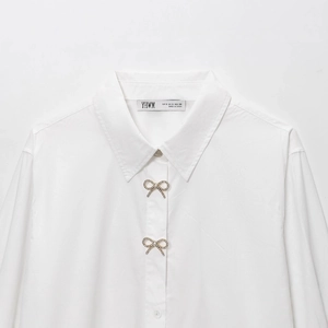 Camicia in popeline bianco da donna con eleganti bottoni gioiello a fiocco di strass