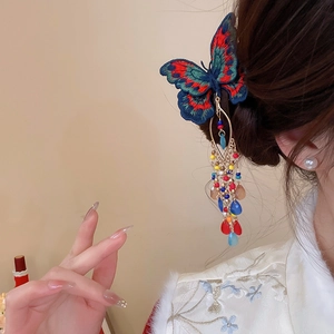 Detailed close-up of embroidered butterfly hair clip with colorful tassel and crystal beads