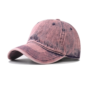 Detail of vintage pink washed denim baseball cap with distressed texture and curved brim