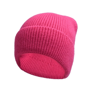 Texture dettagliata del berretto in maglia rosa acceso con motivo a coste e risvolto