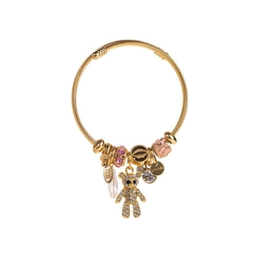 Detailed shot of golden charm bracelet featuring teddy bear and crystal heart pendants