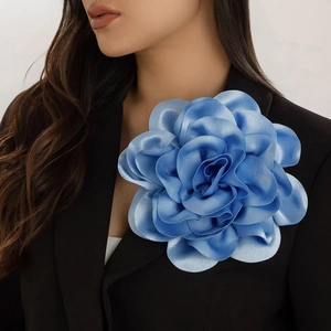 Macro shot of large sky blue fabric rose brooch pinned on a black suit lapel