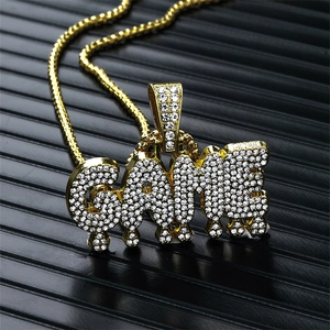 Gros plan du collier hip hop doré avec pendentif GAME et zircons blancs étincelants
