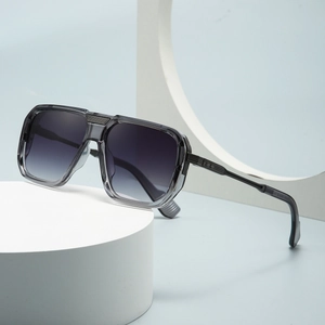 Moderne Pilotenbrille mit grauem Verlaufsglas auf minimalistischem weißem Hintergrund