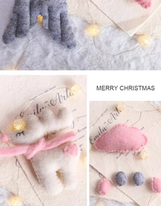 Detail of handmade wool felt Easter deer with pink scarf and cloud ornaments decoration