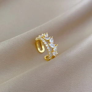 Detail of adjustable gold ring with marquise and round cubic zirconia on beige silk