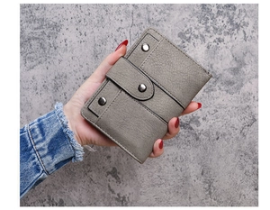 Close-up of gray pebble leather wallet with metal rivets and snap button closure
