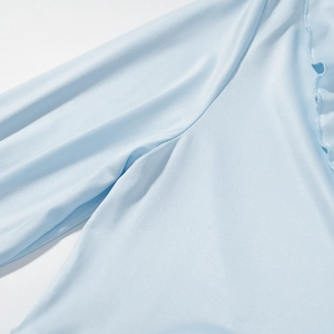 Detailed close-up of light blue ruffled sleeves and premium smooth fabric texture