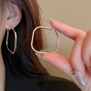 Detail view of silver geometric square hoop earrings with polished metal finish