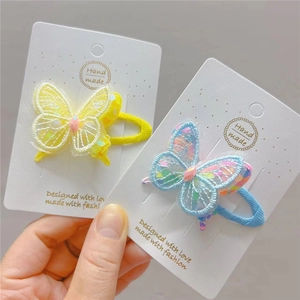 Close-up of embroidered butterfly hair clips with shimmering sequins and 3D mesh detail