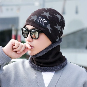 Detail of dark brown knitted winter hat with gray star pattern and soft fleece lining