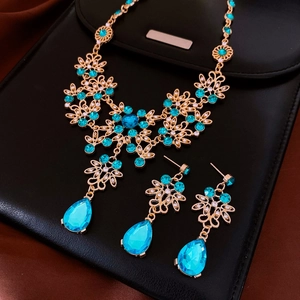 Exquisite gold necklace and earring set with teal teardrop gems and clear crystals
