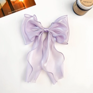 Detail of elegant lavender sheer organza bow hair clip with long flowing ribbons