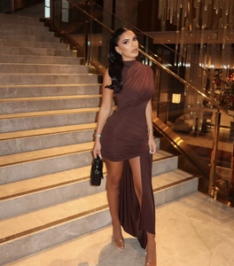 Detail of dark brown ruched slim dress showing elastic silky fabric and asymmetric hem