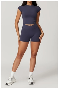 Detail of high-waist yoga shorts with V-cross waistband and matching crop top in navy grey