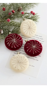 Détail de boules de Noël en velours rouge et beige mat avec spirales dorées