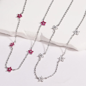 Detailed shot of multi-colored floral pendants with gemstones on silver metal chains