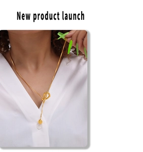Detail of adjustable gold bead slider and white shell pendant on stainless steel chain