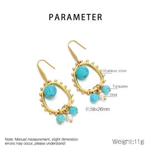 Detail of bohemian gold earrings with turquoise and shell charms in oval design