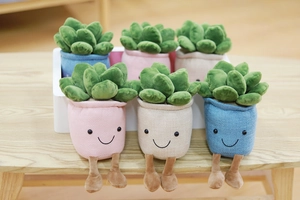 Set of six colorful plush succulent plant toys in various shades on a wooden table