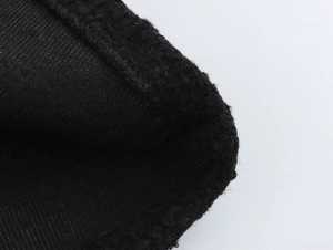 Dettaglio ravvicinato della trama del tessuto tweed nero e delle cuciture di alta precisione